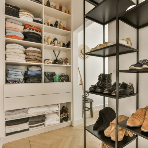 the inside of a walk - in closet with shoes and other items on shelves, as well as they do